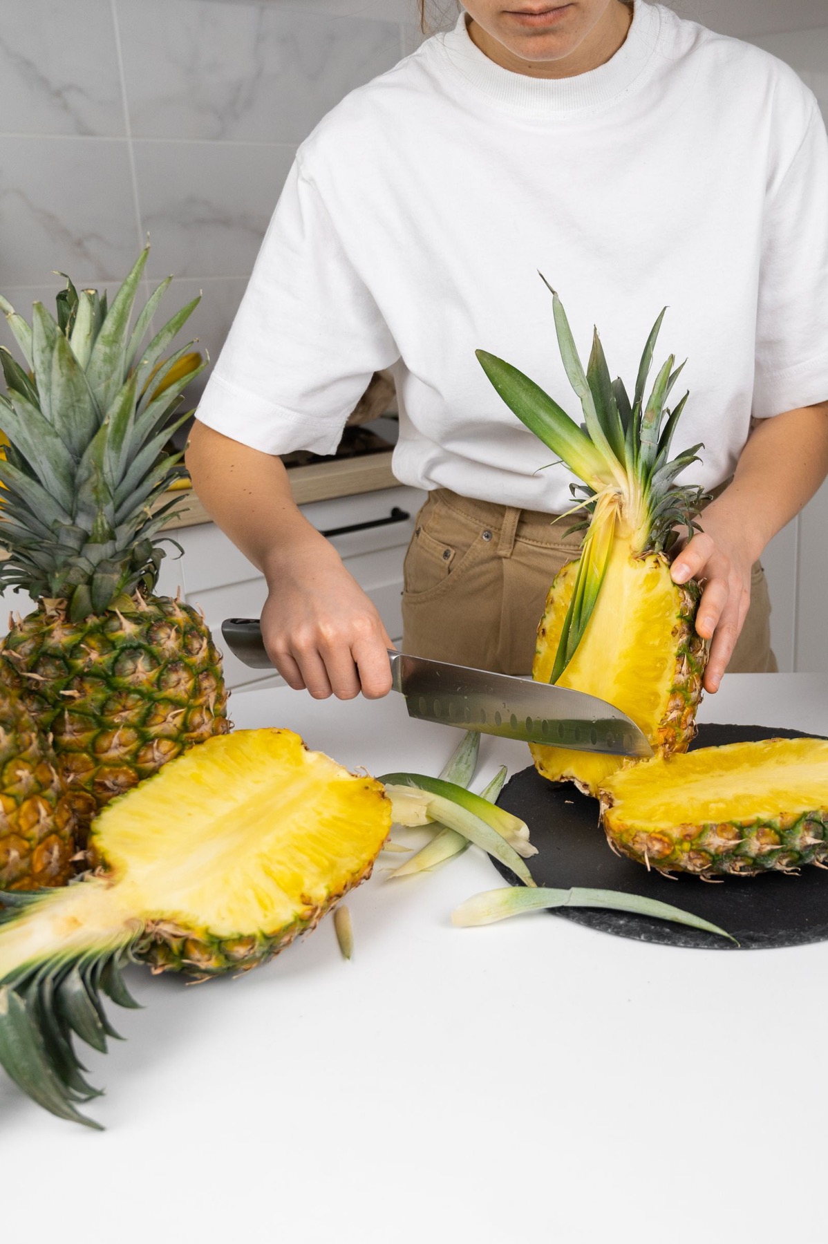 Fresh pineapple being carefully prepared on a cutting board