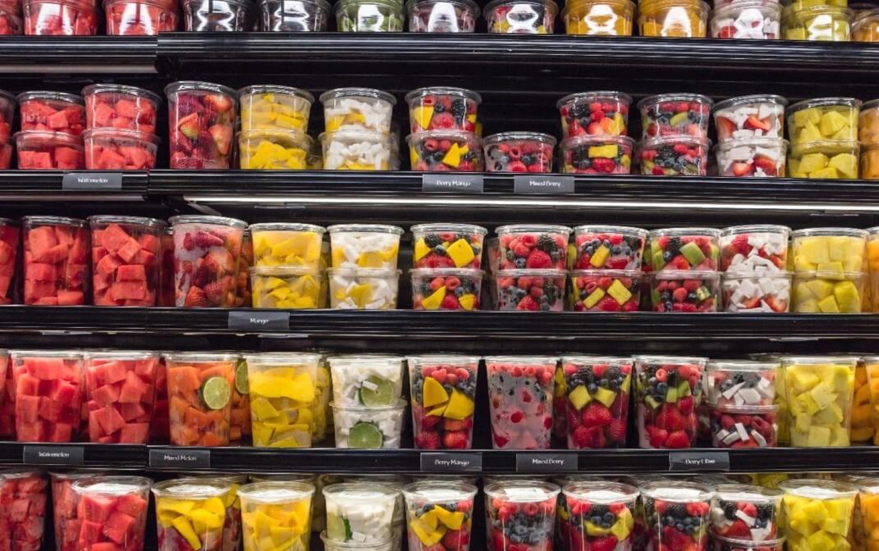 A bright retail display of packaged fresh fruit